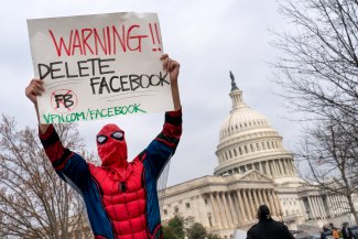Facebook protester with Warning Delete Facebook sign, Washington DC.